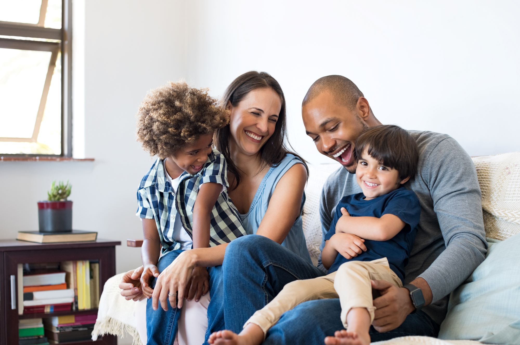 Couple with two little kids sitting on a couch