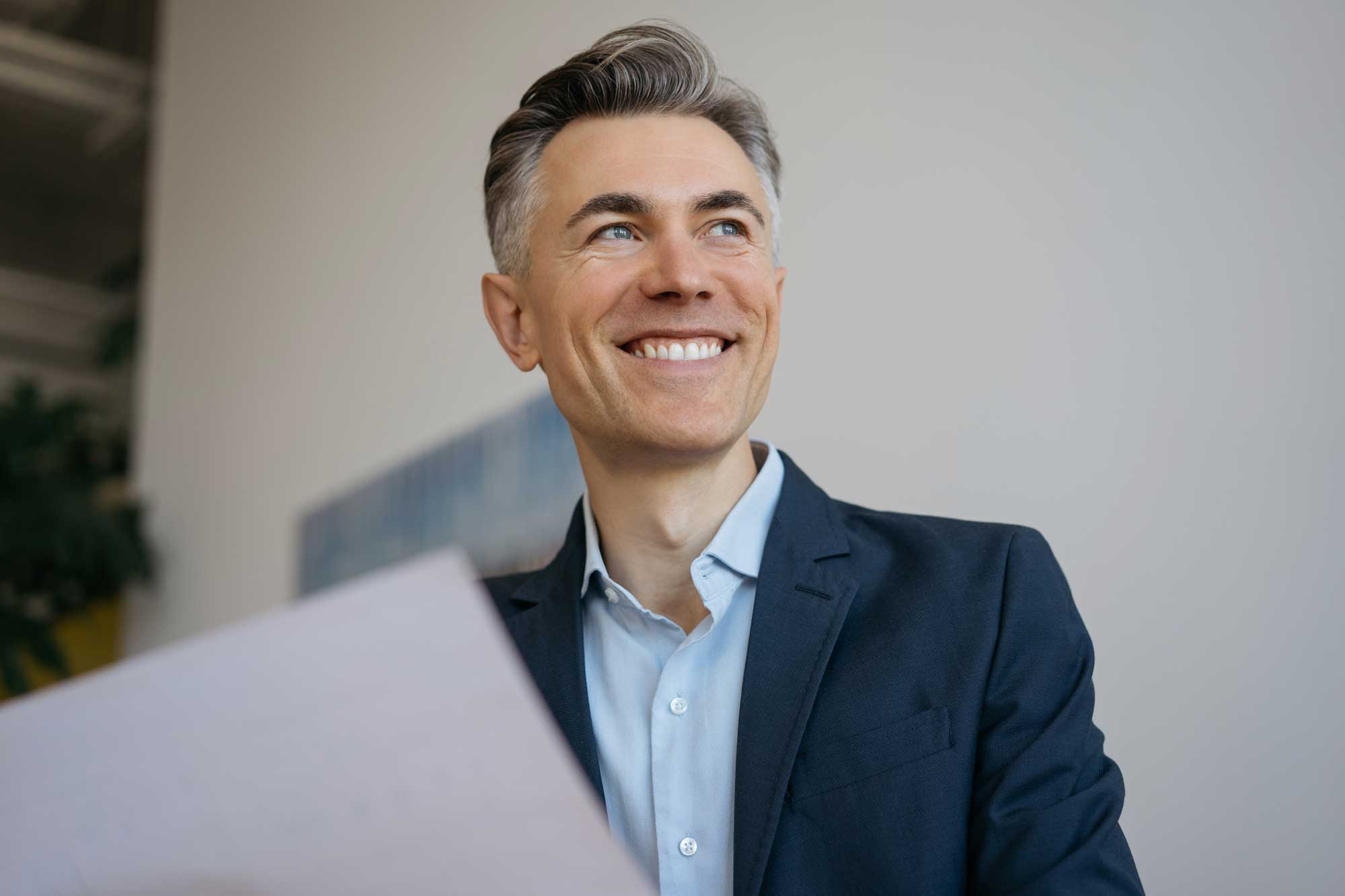 handsome-mature-businessman-holding-contract-or-financial-documents-sitting-in-office.-successful-business